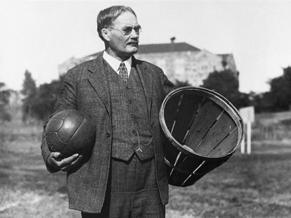 Black-and-white photograph of James Naismith, the inventor of basketball, holding a leather soccer ball and fruit basket c.1891. Sourced from Worldbook.