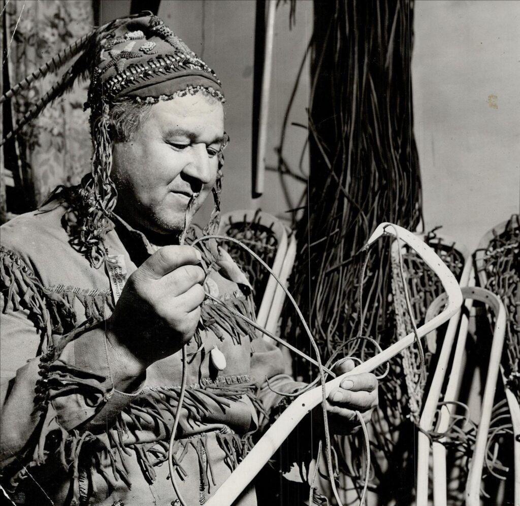 A photograph from the Toronto Star with the original caption: "The Mohawk; one of the brilliant lacrosse-playing Martins; scalped a good many palefaces in his active playing days. Now on the Brantford reserve; he makes the best lacrosse sticks in all Canada and as a result the world beats a path to his door. He has a big export market." Image by Harold Barkley and sourced from the Toronto Public Library.
