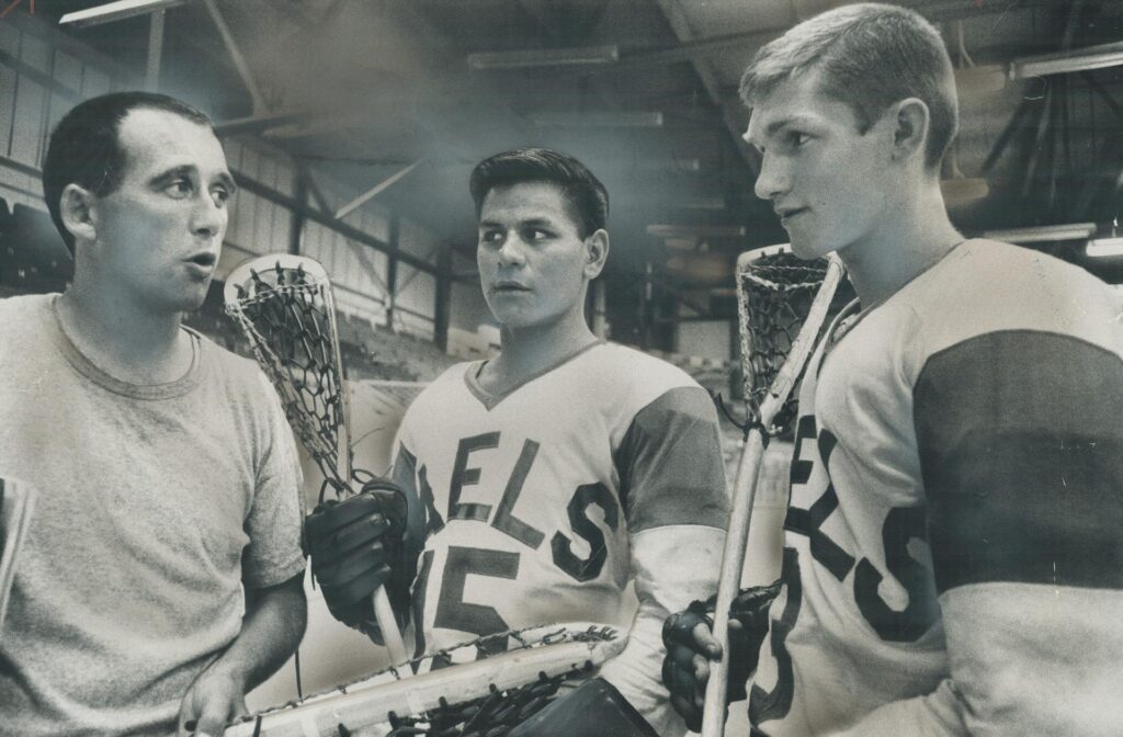 A photograph from the Toronto Star featuring Jim Bishop (left), Gaylord Powless (centre), Ross Jones (right), published on May 4, 1967. The original article had the caption: "Why Oshawa Favored for 5th Title. Oshawa Green Gaels are heavily favored to win their fifth consecutive Canadian junior lacrosse title. Here coach Jim Bishop (left) lectures his big shooters; Ross Jones (centre) and Gaylord Powless. Jones scored 204 points last season while Powless had 187. They'll join Peterborough Petes; 1966 senior champions; to play in centennial international field lacrosse tournament opening in Toronto May 17." Image by Mario Geo and sourced from the Toronto Public Library.
