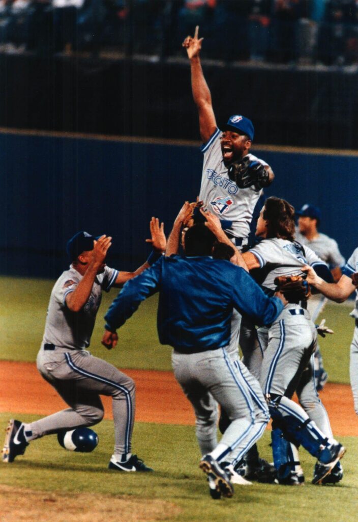A photograph of Toronto Blue Jay Joe Carter leading a celebration at the end of game 6 on June 22, 1992 at the 1992 Atlanta World Series. The image was featured in the Toronto Star. Image created by Mike Slaughter and sourced from the Toronto Public Library.