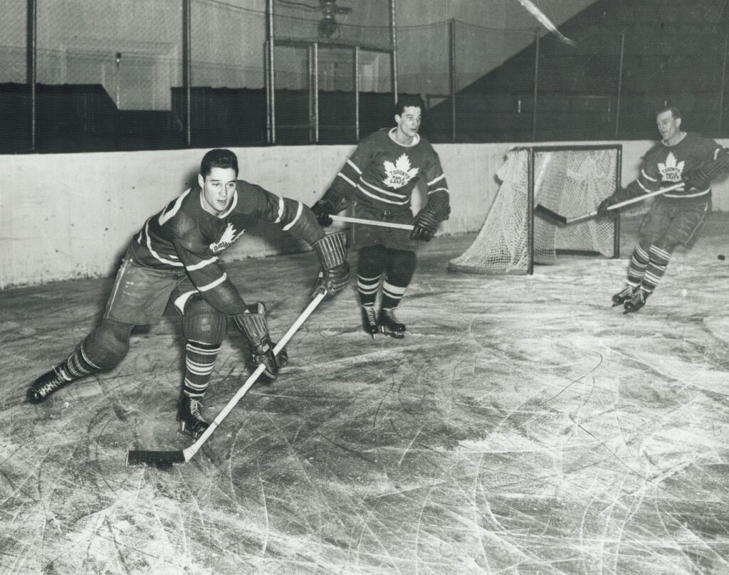 A photograph of Jim Thomson of the Maple Leafs practicing with his teammates. The original caption for this image in the Toronto Star was: "Traded for a race horse: Jim Thomson was traded by Conn Smythe of the Leafs to Chicago for a race horse. He is now chairman of the board of McKinnon Fuels Ltd." Image taken by Jeff Goode and sourced from the Toronto Public Library.
