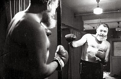 A photograph of Ernest Hemingway shadow-boxing in the mirror. Image sourced from Peter Chrisp blog.