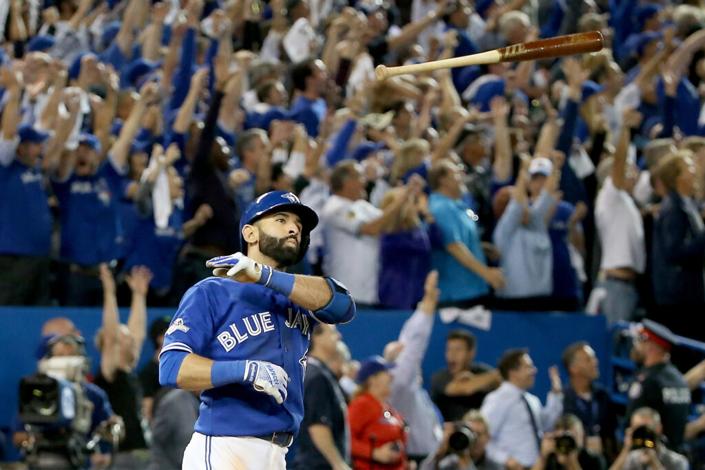 TORONTO, ON - OCTOBER 14: Jose Bautista #19 of the Toronto Blue Jays throws his bat up in the air after he hits a three-run home run in the seventh inning against the Texas Rangers in game five of the American League Division Series at Rogers Centre on October 14, 2015 in Toronto, Canada. Photo by Tom Szczerbowski/Getty Images and sourced from Time.